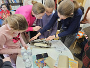 Майя Димерли (справа) показывает, как работает печатная машинка со шрифтом Брайля